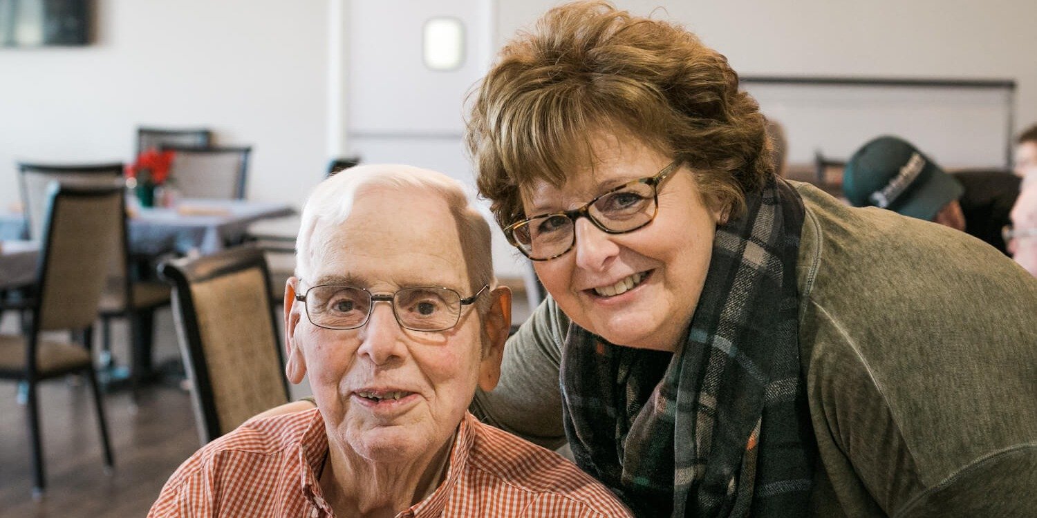 Middle-aged caregiver smiling with senior father