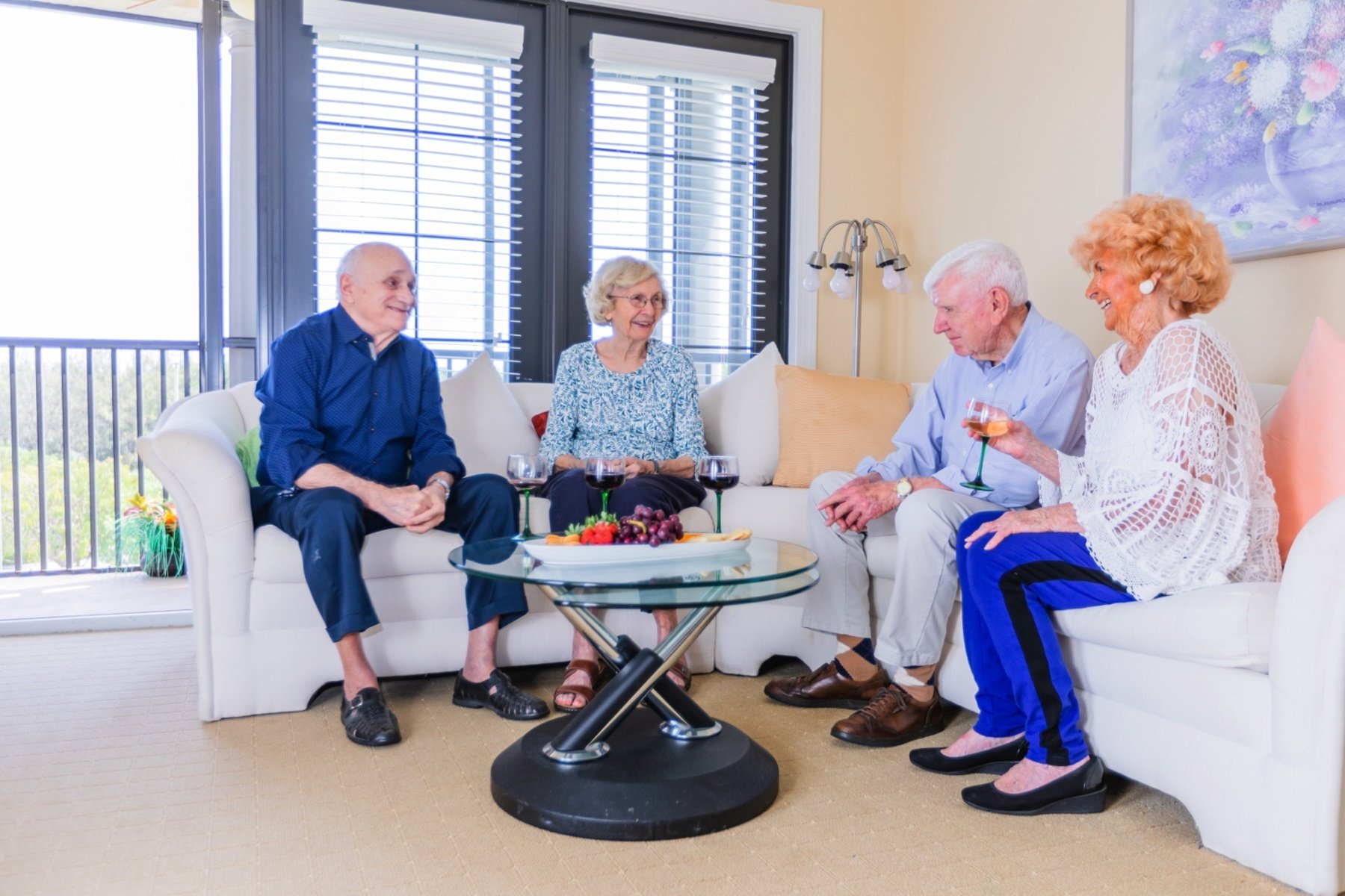 Senior friends enjoying drinks together in an apartment