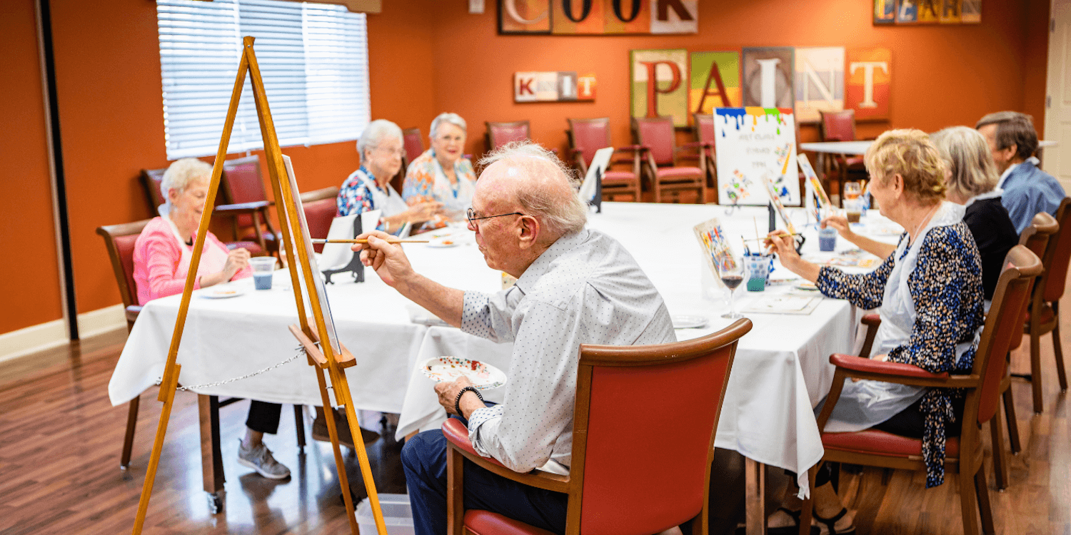 Senior residents enjoying a session of group painting.