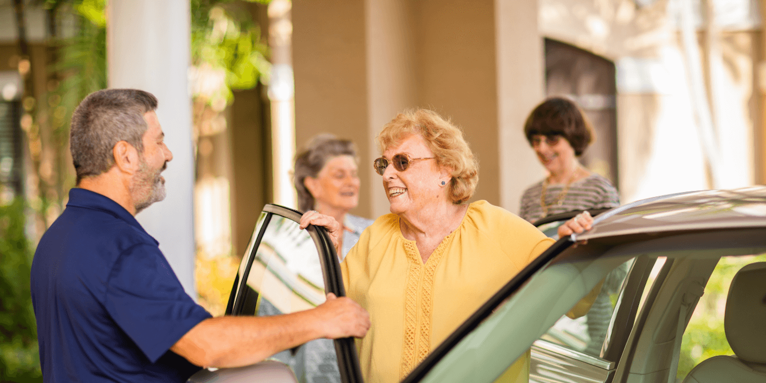 senior woman getting out of a car to greet valet