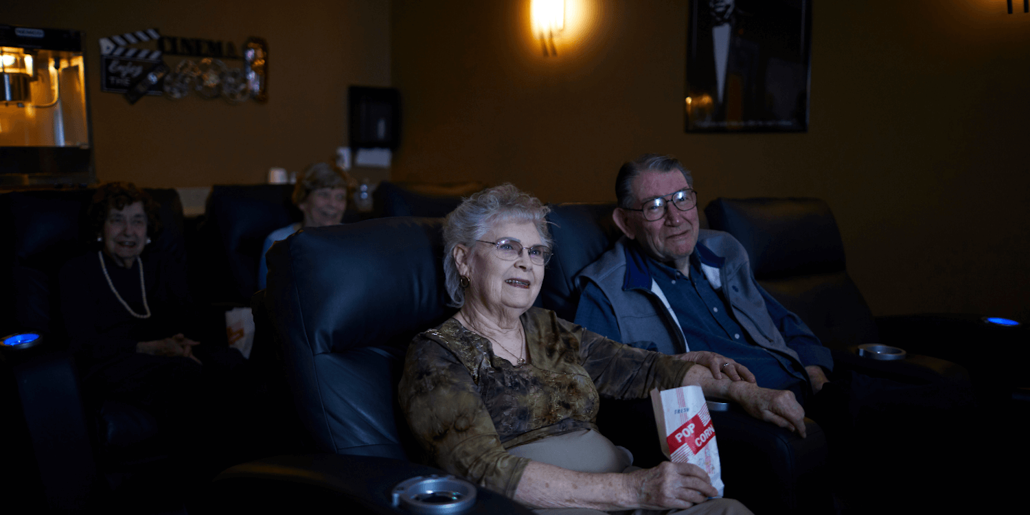 resident couple eating popcorn and watching a movie together