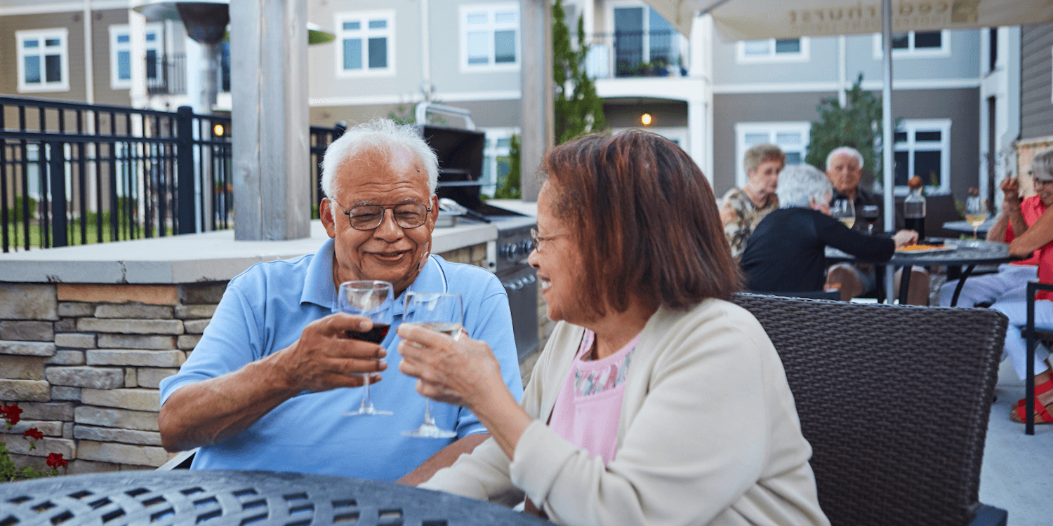 Two residents enjoying glasses of wine together outside