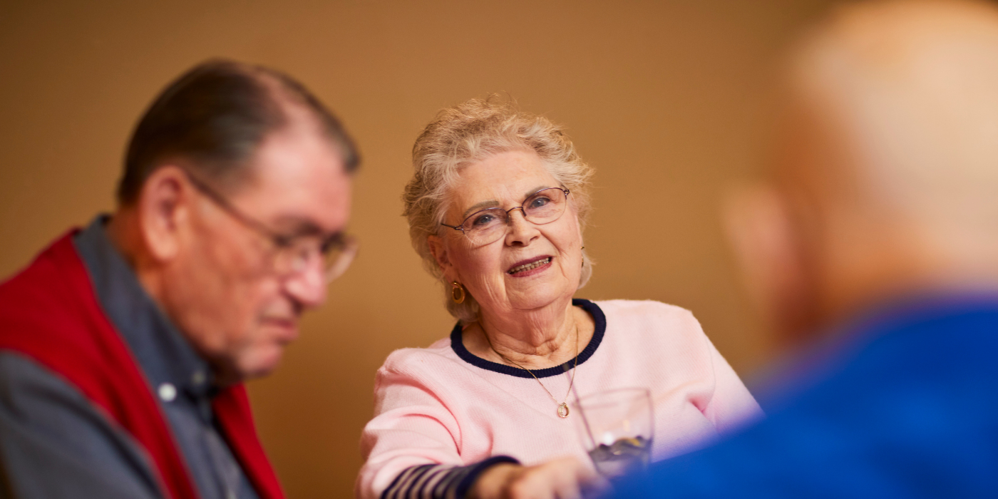 Senior living residents discuss pricing while enjoying a drink together. 