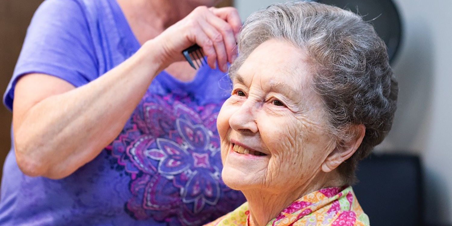 Caregiver doing residents hair