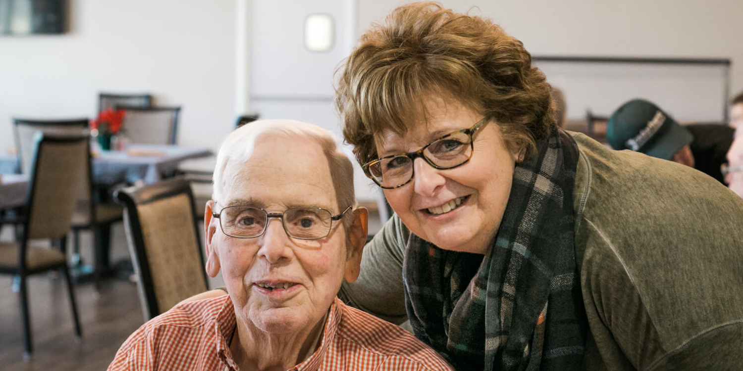 A Cedarhurst team member and senior resident in the community dining room, talking about senior living