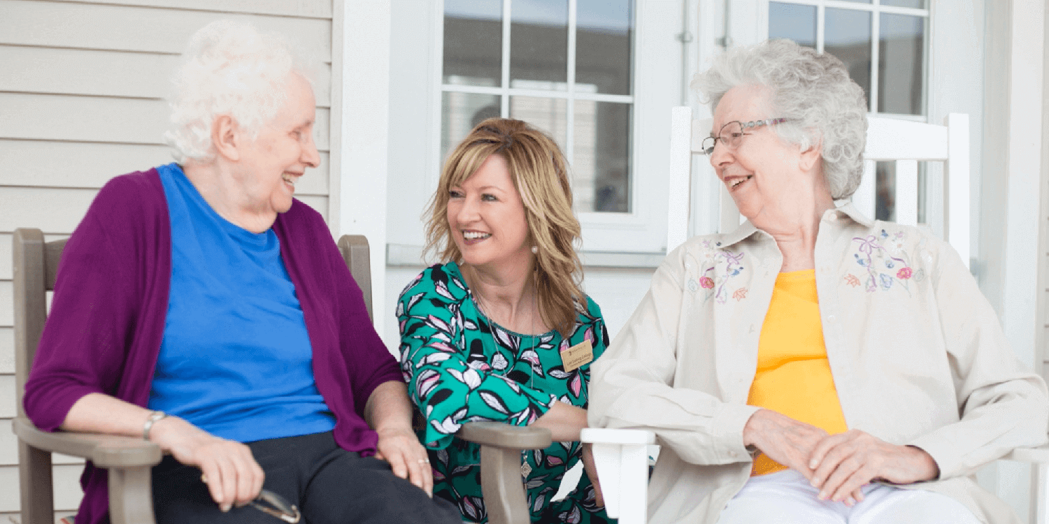 Caregiver laughing outside with residents