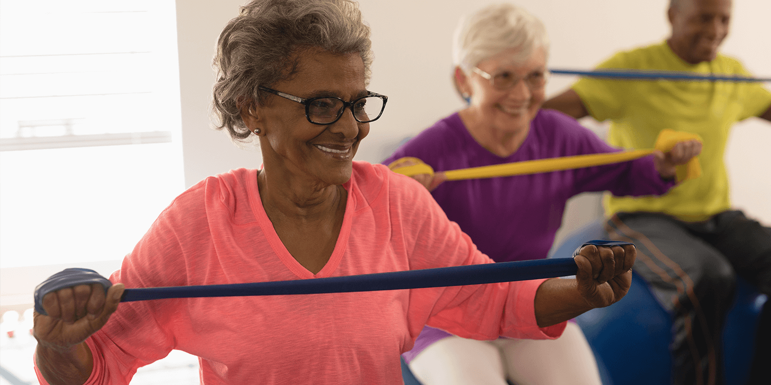 Group of seniors exercising with resistance bands in a senior living community