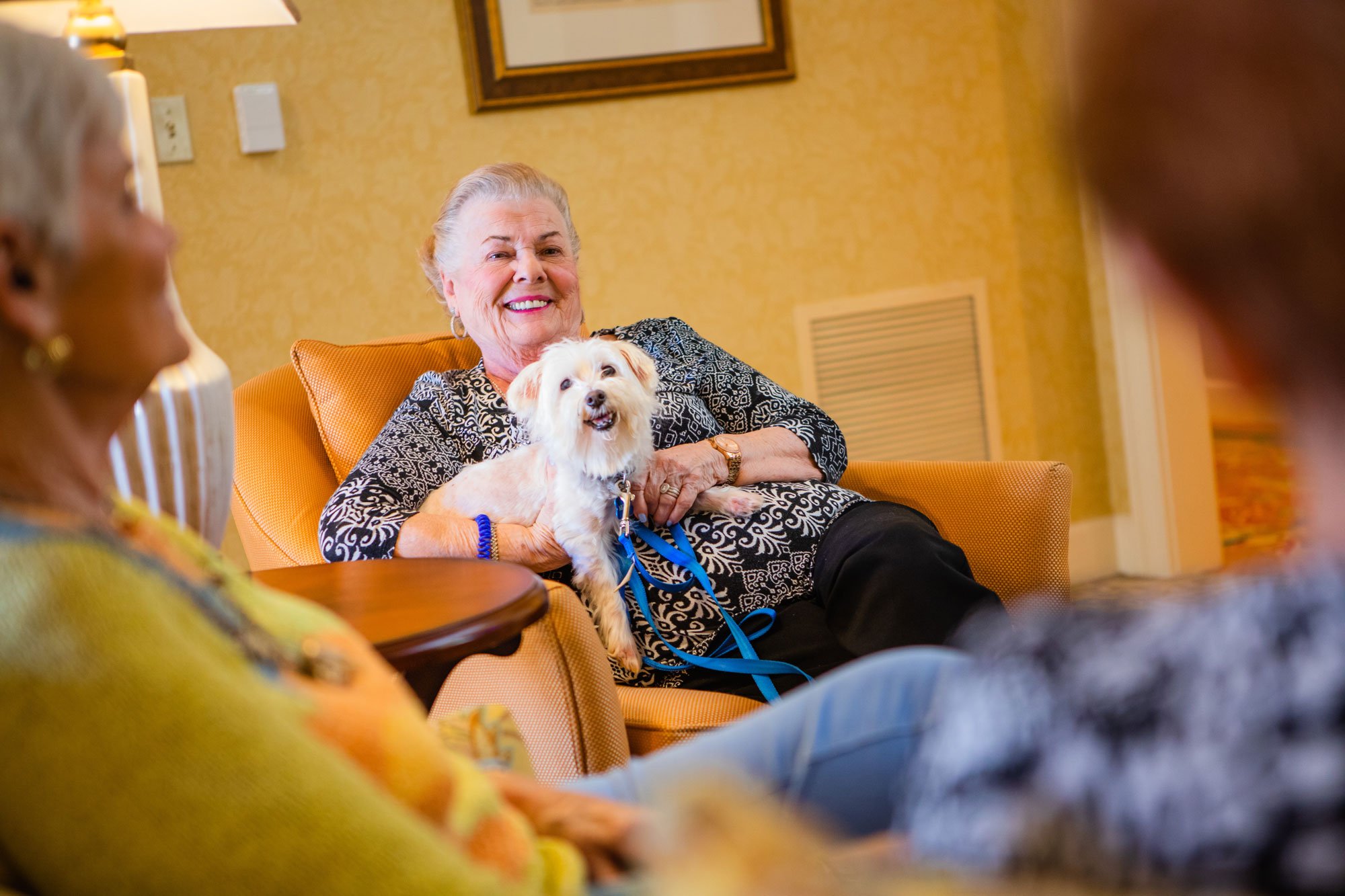 Smiling Cedarhurst resident with her dog on her lap
