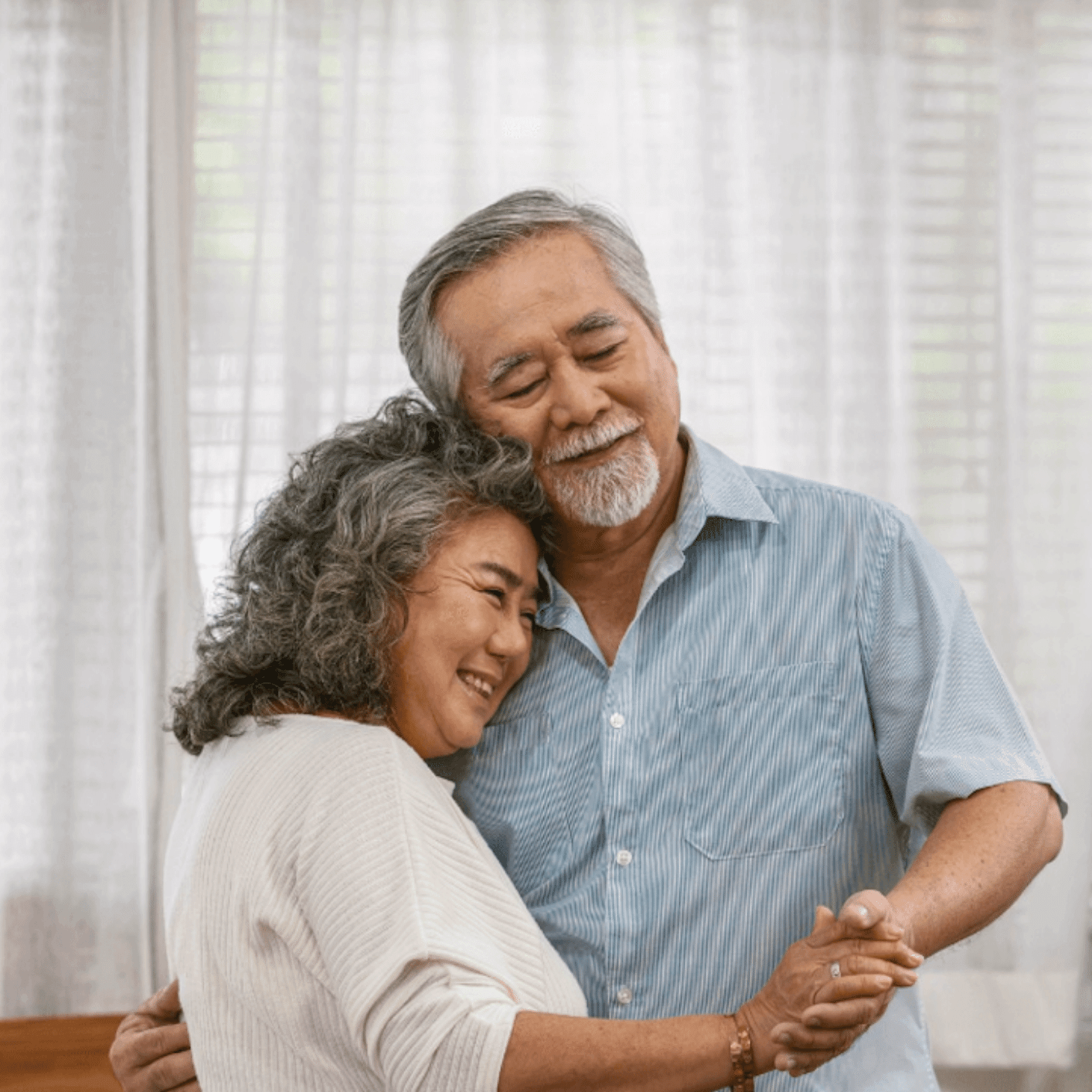 Two residents smiling and hugging eachother