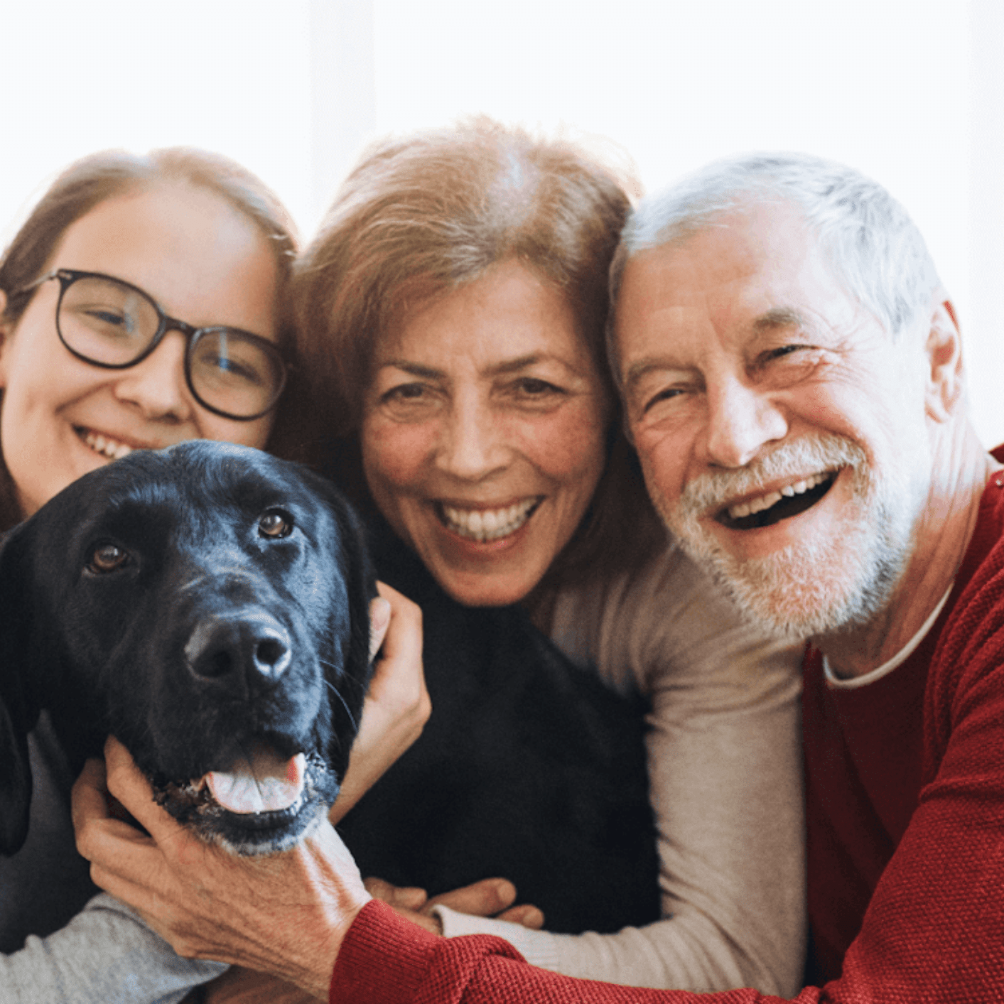 A family and a dog smiling together
