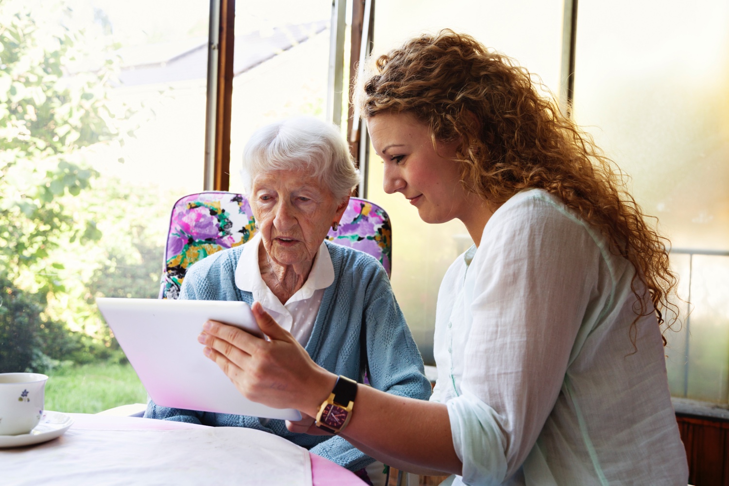 Carer holding tablet for senior