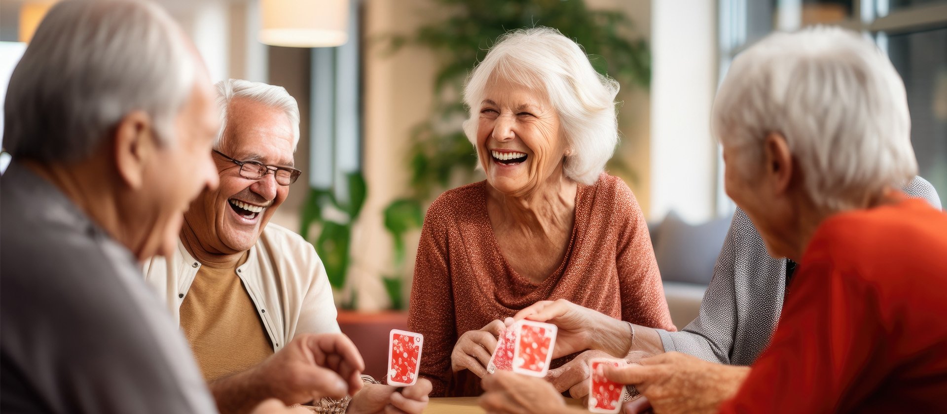 A group of senior living residents playing a game of cards and smiling