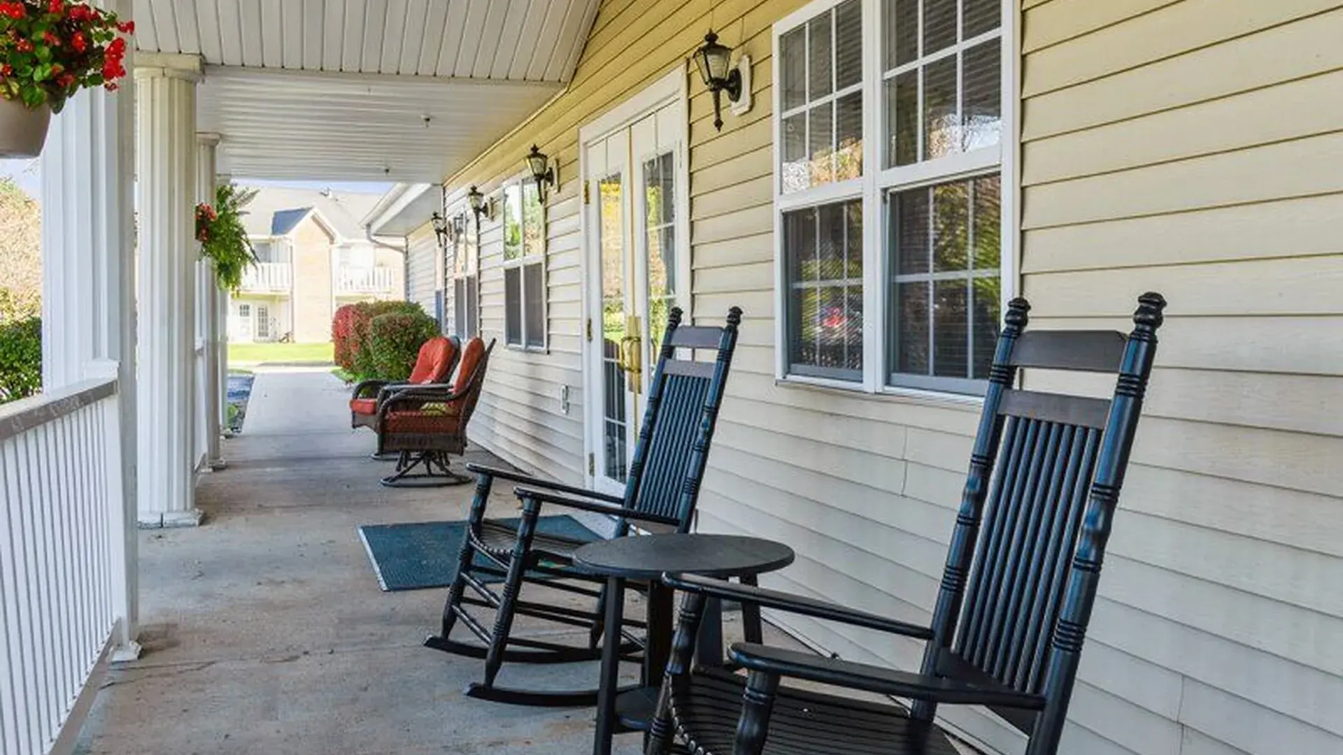 An accessible covered porch at Cedar Creek of Marion equipped with rocking chairs and fans