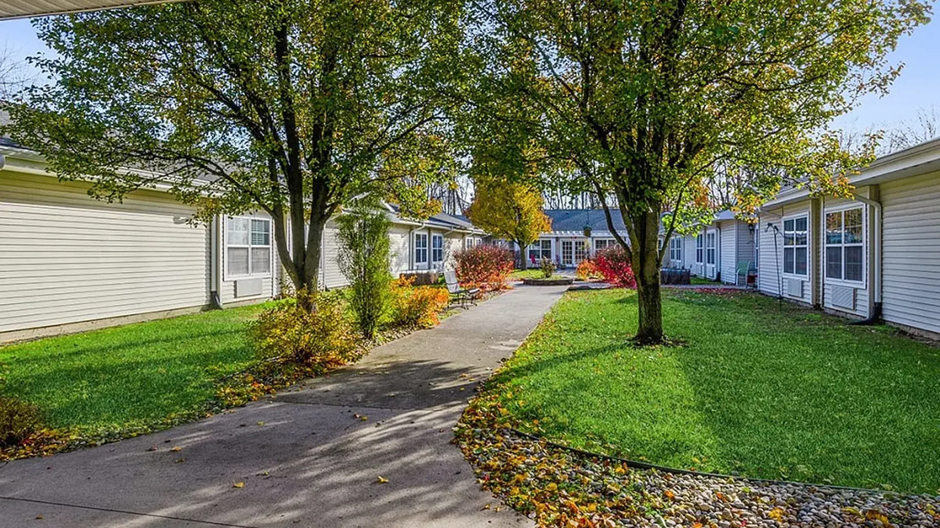 An inviting outdoor area at Cedar Creek of Warsaw, showing lush green spaces and paved paths