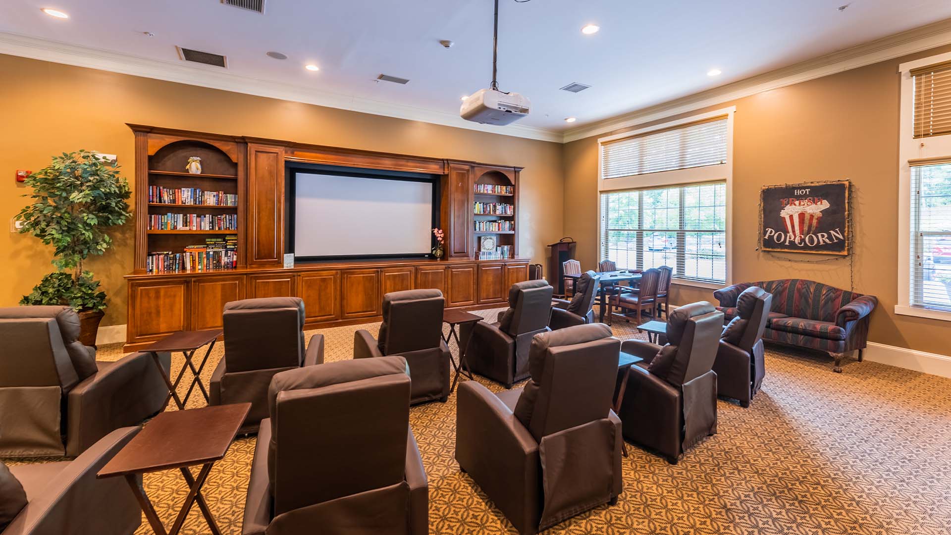 A comfortable and accessible movie theater at Cedarhurst of Canton, featuring a large screen and plush seating for residents' enjoyment