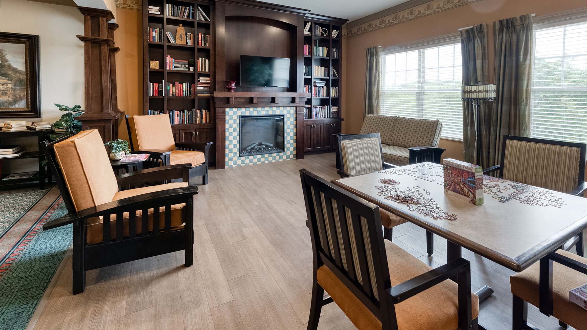 Accessible common area at Cedarhurst of Columbia that includes couches, a fireplace, and a game table