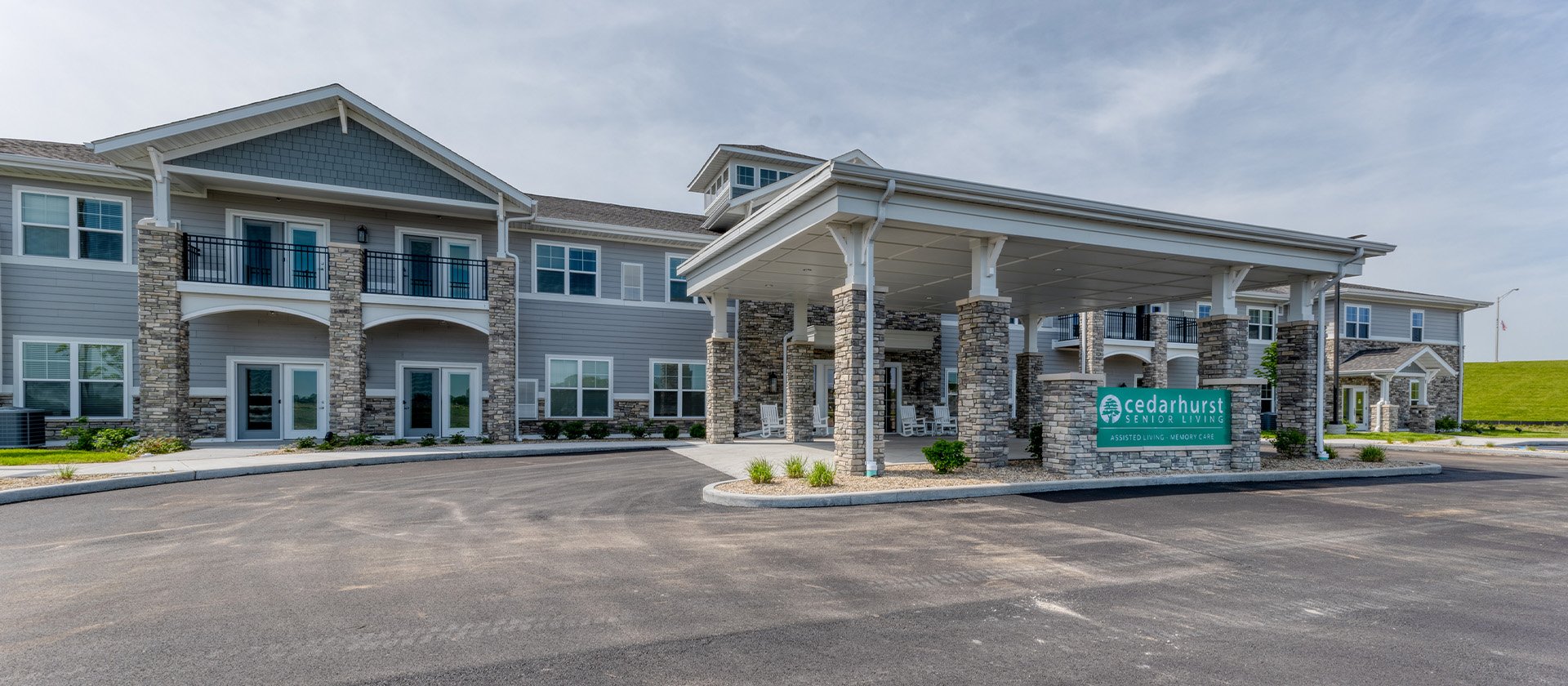 An inviting view of the Cedarhurst of McHenry senior living community from the outside, complete with the main building and its distinctive sign.