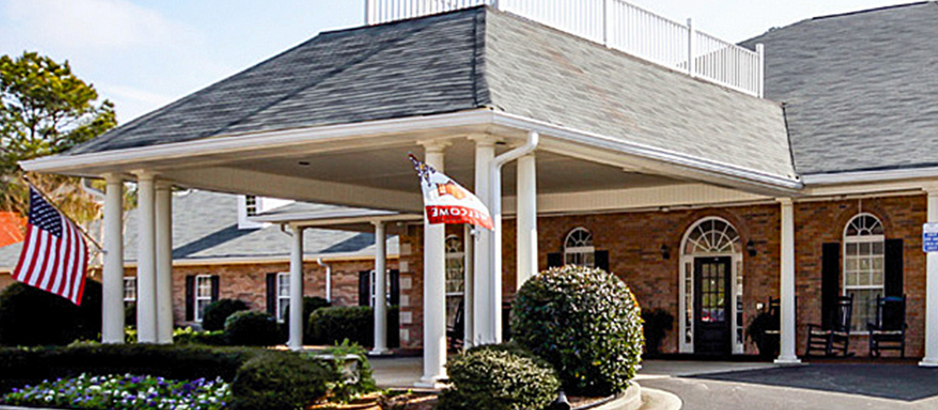 An inviting view of the Cedarhurst of Oakwood senior living community from the outside, complete with the main building and its distinctive sign
