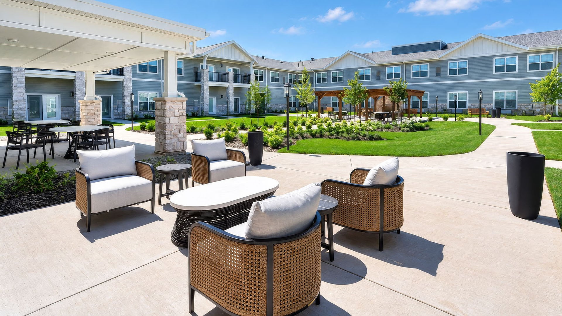 An inviting outdoor space with paved walking paths and a wooden pergola at Cedarhurst of Shawnee senior living community