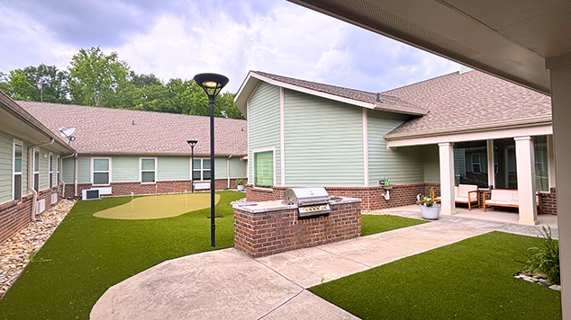 Outdoor courtyard space at Cedarhurst of Spartanburg with paved walking paths and comfortable seating