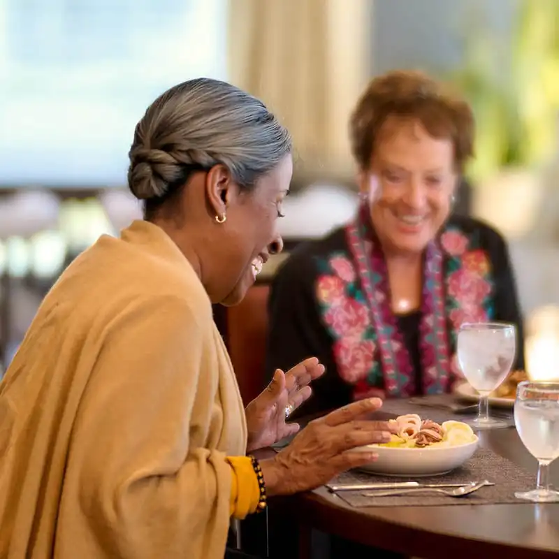 Residents at senior living community in dining room enjoying a meal together