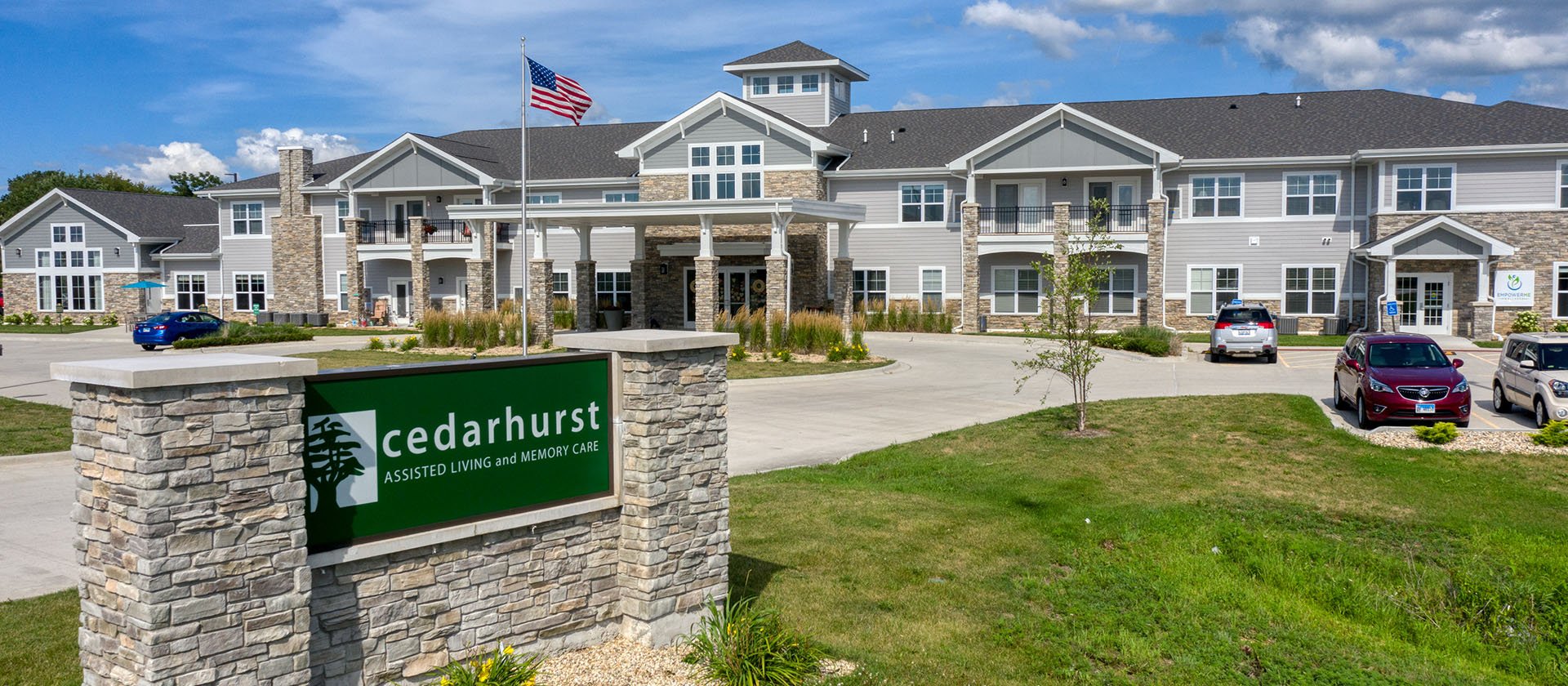 An inviting view of the Cedarhurst of Yorkville senior living community from the outside, complete with the main building and its distinctive sign