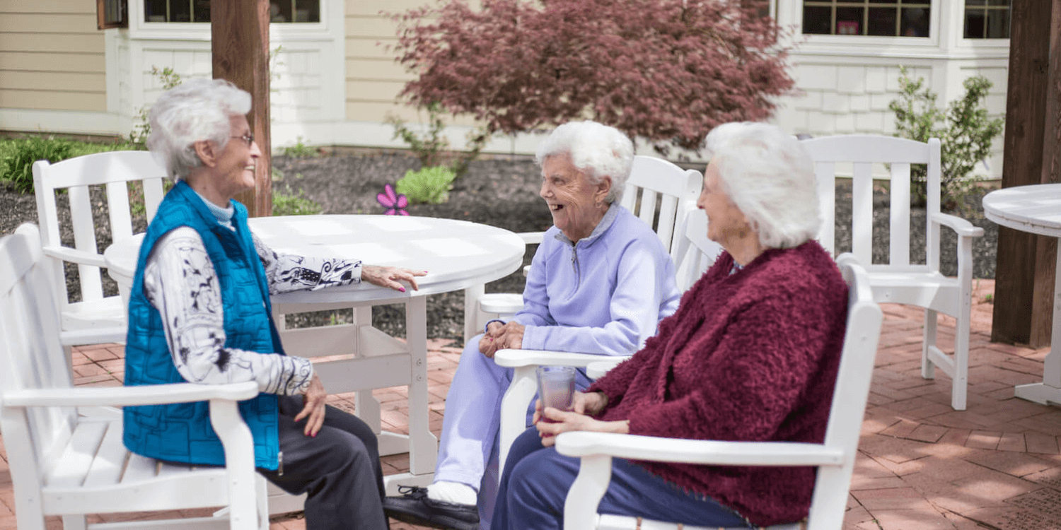 Group of assisted living residents chatting outside