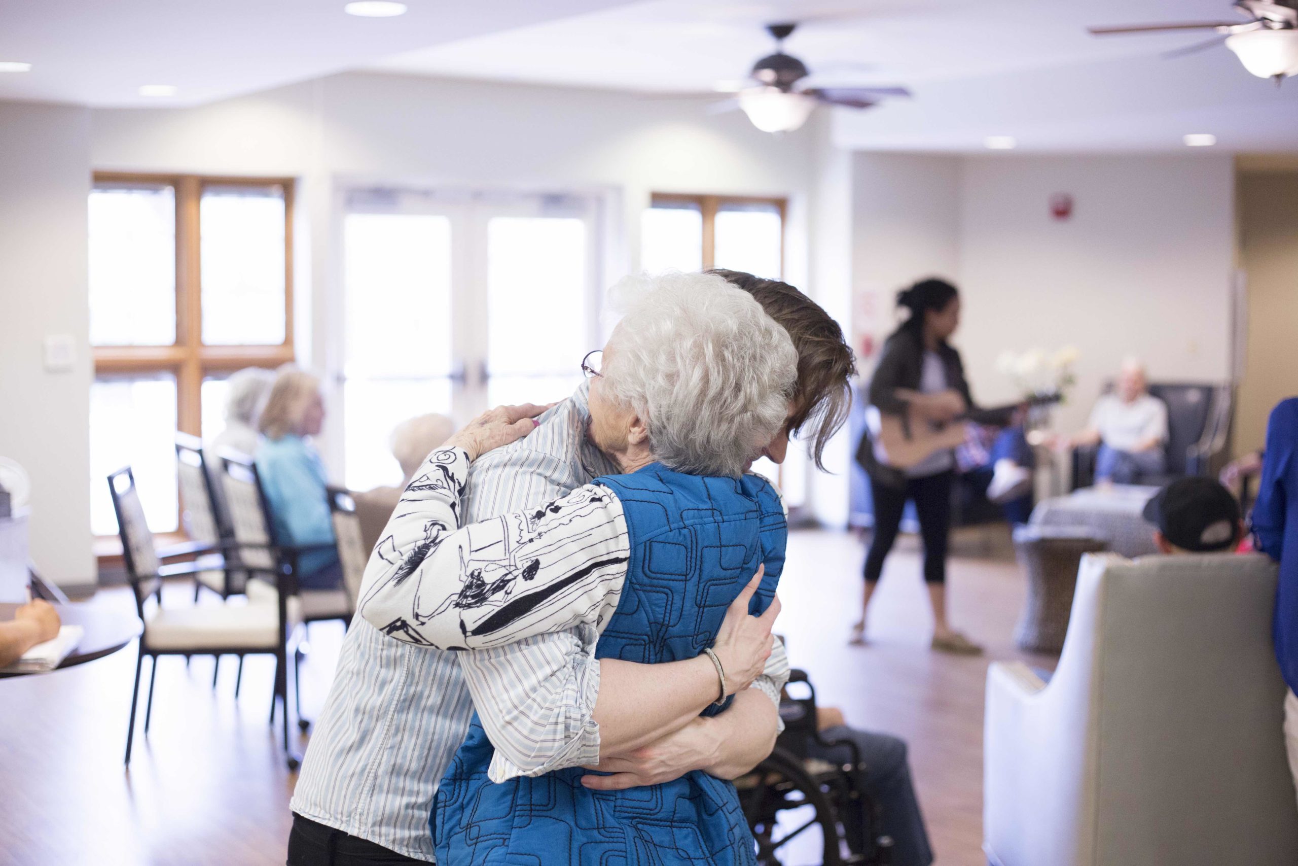 Senior and staff member hugging