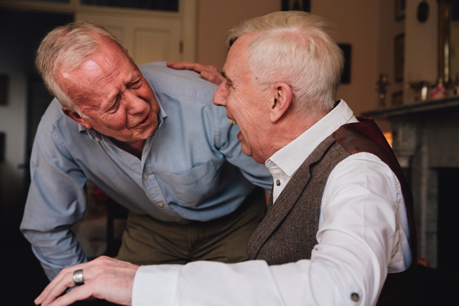 Two senior men laughing and embracing