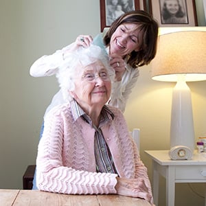 Caregiver combing senior's hair