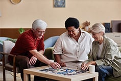 Senior living residents assembling a puzzle together