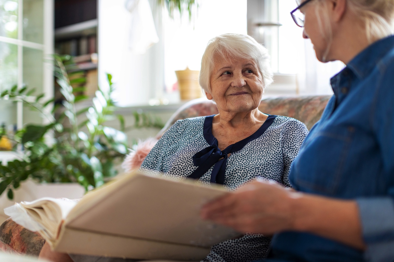 Senior woman and caregiver viewing photo book