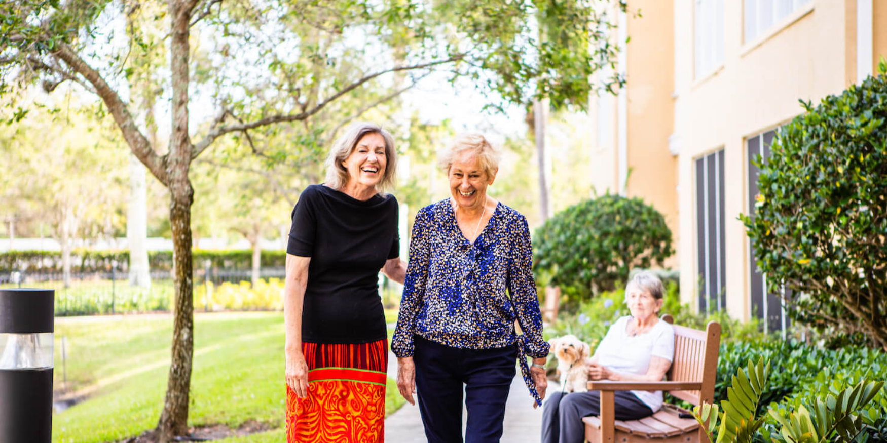 Two women walking outside a senior living community 