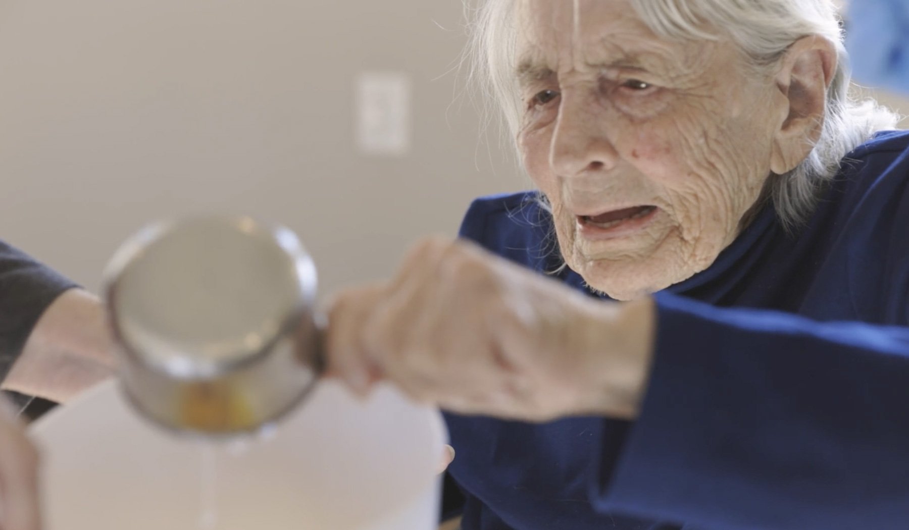memory care resident using a mesauring cup to bake