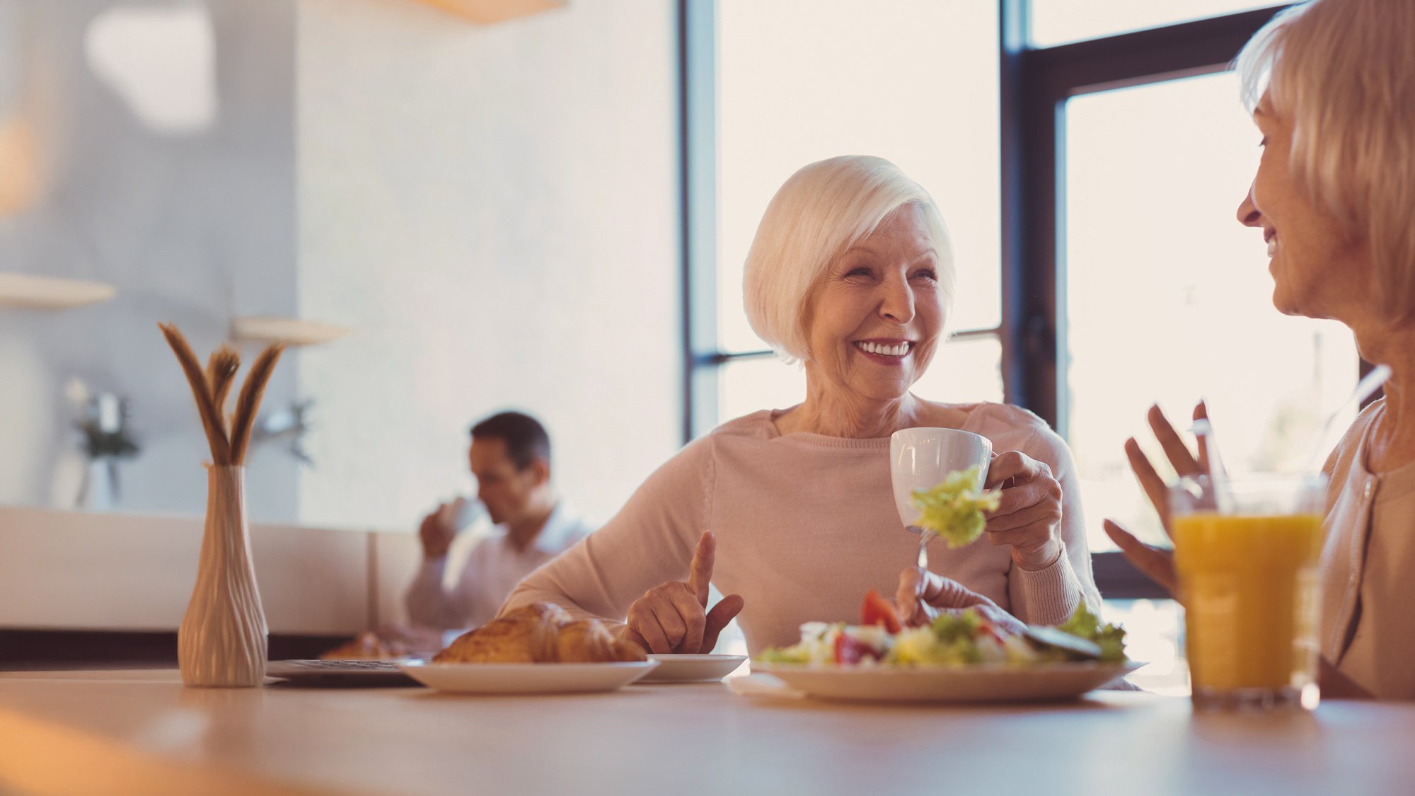 senior woman having lunch with a friend at a restaurant