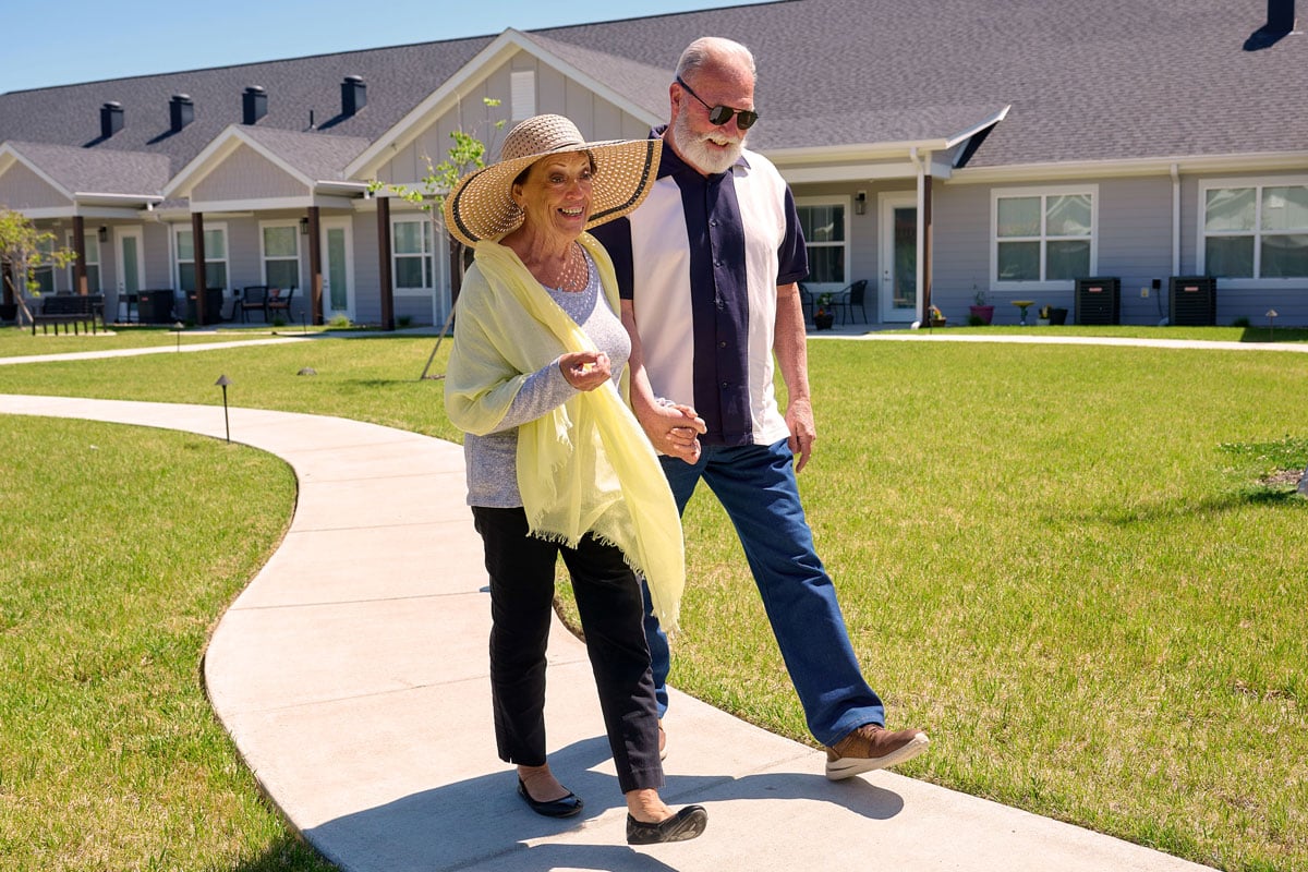 seniors walking on sidewalk path in community